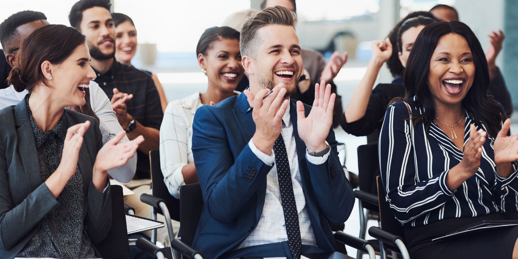 People dressed smartly clapping and smiling